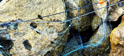 Sea torn fishing net on rocks. Summer sea fishing
Fishing background
