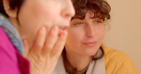 Two women engage in a lively conversation one has beautiful curly hair while the other wears a thoughtful expression, highlighting their connection and meaningful interaction