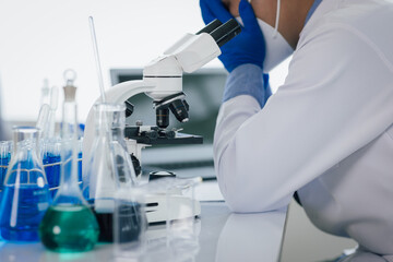 Medical scientist feeling stressed while working using microscope in laboratory, feeling stressed while doing some research, failed experiment.