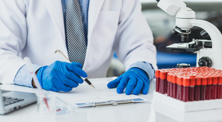 Scientist analyzing blood test results in a laboratory. Scientist in a lab carefully examines blood test results, focusing on precision and attention to detail in medical analysis.