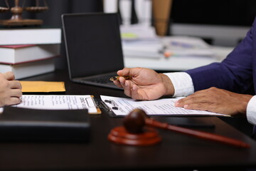Lawyer reviewing contract agreement with legal documents, Discussing contract agreement at desk with legal document.