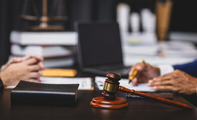 Lawyer reviewing contract agreement with legal documents, Discussing contract agreement at desk with legal document.