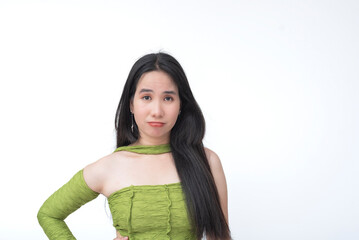Teen asian girl raises an eyebrow with a skeptical and unimpressed face while wearing a green...