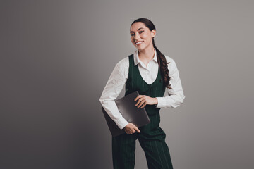 Stunning Confident Businesswoman Holding a Laptop Posed Against a Neutral Studio Background