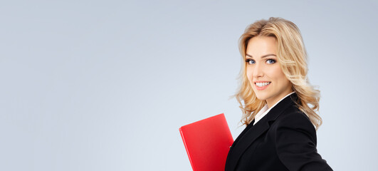 Portrait image - happy smile business woman businesswoman teacher manager real estate agent hold red folder. Blond hair girl in black jacket. Isolated grey gray background. Ad concept. Free text space