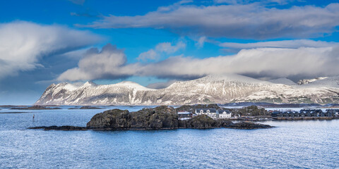 on tour of the island of Senja. Steep mountains in winter, snowy landscape on the shore of...