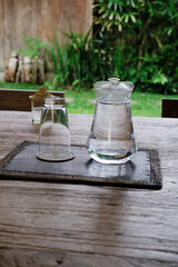 Glass Carafe with Water and Upside-Down Glass on Wooden Table