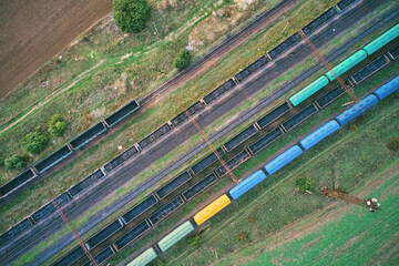 Aerial drone view of a freight train at a railway station, showcasing industrial transport infrastructure with steel tracks and cargo carriages. Ideal for logistics themes.