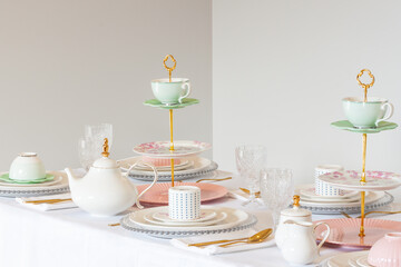 Elegant wedding table setting with pink peonies, gold cutlery, and crystal glassware, creating a romantic and sophisticated atmosphere.