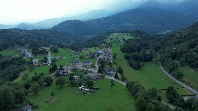 Drone panorama of the Ivrea Morainic Amphitheatre seen from Brosso, Val Chiusella, Italy, showing lush green plains, woods, and scattered villages under clear sky, high drone shot, slow motion