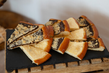 Slices of traditional czech kolache with poppy seeds and curd cheese filling lying on black slate...