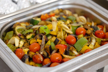 Grilled vegetables, peppers, onions, zucchini, eggplant and cherry tomatoes filling a catering tray