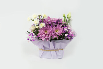 Bouquet of different purple flowers as a gift, white background. Gift for a holiday, Women's Day, Wedding, Mother's Day, March 8.