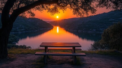 Sunrise over tranquil lake, picnic table under tree