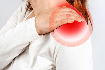 The hands of the woman massage a painful shoulder or neck muscles. Inflamed male joint, stiffness...