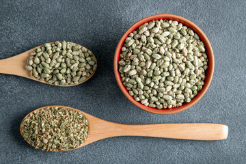 A bowl filled with a pile of natural dried thyme, alongside a spoon containing thyme seeds
