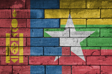 colourful painted big national flag of myanmar and flag of mongolia on a massive old brick wall background. concept