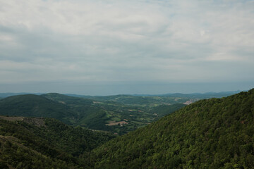 Panoramic view from Vujan Mountain, Serbia, revealing valleys, farmlands, and distant towns under a cloudy sky. Travel in Serbia country. Spring calm landscape.
