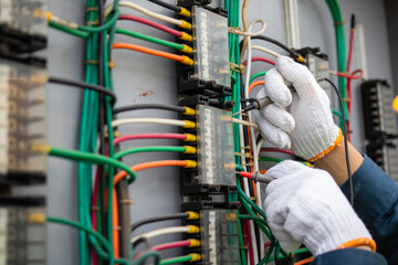 Power engineer is working at substation, skillfully handling electrical components with precision...