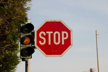 Traffic light with a stop sign on the right side, symbolizing safety, traffic regulation, and the...