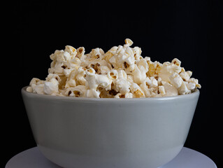 Bowl of popcorn isolated against a black background.