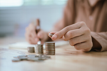Money saving ideas: woman puts money in a piggy bank, analyzes expenses