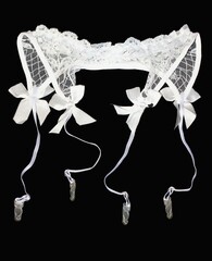 Women's white lace garter on a black background.
