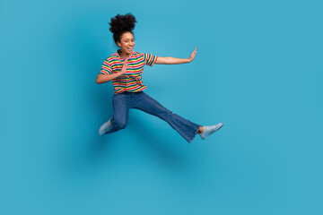 Obraz premium Smiling young woman with energetic pose in casual outfit and wide gesture on blue background, modern joyful lifestyle