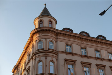 This photograph features a historic building with a turret, bay windows, and intricate architecture, highlighting classical design in an urban setting for a striking visual contrast
