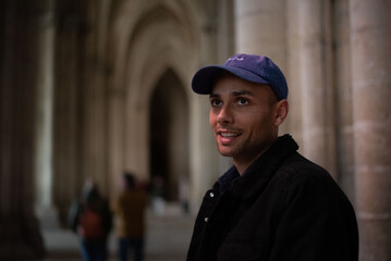 A young man explores the interior of a historic church, admiring its architecture and spiritual atmosphere. The scene reflects cultural discovery, spirituality, and travel. 