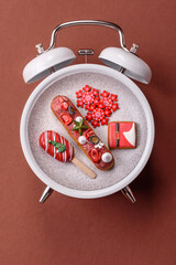 Christmas, eclair on a plate on a vintage clock. Christmas time conceptual background