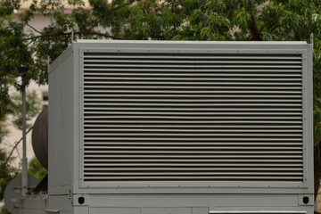 This image prominently illustrates a substantial industrial air conditioning unit that is equipped...