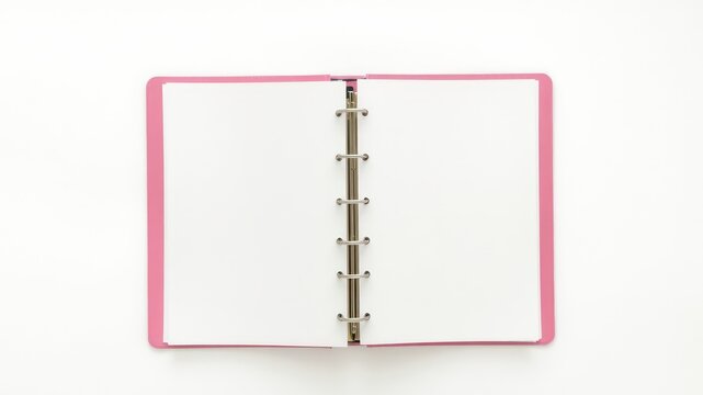 Open pink binder with blank white pages lying flat on a white surface waiting for notes and ideas