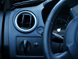 Fototapeta premium Close-up of the car dashboard with switches, buttons and air vents on it.