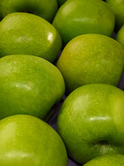 Fresh green apples arranged in a market display, highlighting their vibrant color and texture
