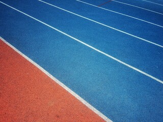 orange and blue Running track with white stripes  in top view.