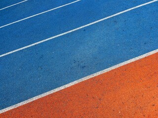 orange and blue Running track with white stripes  in top view.