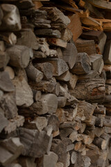 Wood logs are meticulously stacked in an organized area, prepared for both indoor and outdoor use, showcasing a diverse array of sizes and textures of highquality firewood