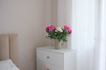 An Elegant Bedroom Corner Bathed in Soft Lighting Surrounded by Fresh Flowers and Beauty