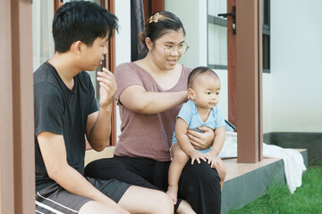 At home, a baby plays with their parents and aunt, sharing moments of laughter and occasional tears. The lively atmosphere reflects the warmth, joy, and emotional ups and downs of family life.
