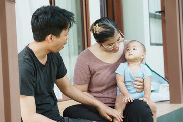 At home, a baby plays with their parents and aunt, sharing moments of laughter and occasional tears. The lively atmosphere reflects the warmth, joy, and emotional ups and downs of family life.
