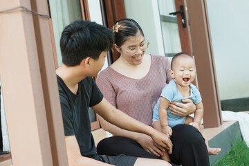 At home, a baby plays with their parents and aunt, sharing moments of laughter and occasional tears. The lively atmosphere reflects the warmth, joy, and emotional ups and downs of family life.
