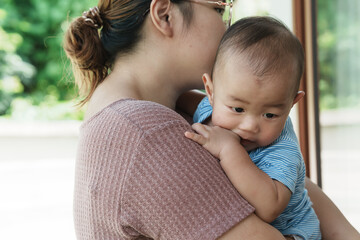 At home, a baby plays with their parents and aunt, sharing moments of laughter and occasional tears. The lively atmosphere reflects the warmth, joy, and emotional ups and downs of family life.
