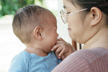 At home, a baby plays with their parents and aunt, sharing moments of laughter and occasional tears. The lively atmosphere reflects the warmth, joy, and emotional ups and downs of family life.
