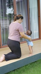 At home, a baby plays with their parents and aunt, sharing moments of laughter and occasional tears. The lively atmosphere reflects the warmth, joy, and emotional ups and downs of family life.
