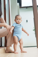 At home, a baby plays with their parents and aunt, sharing moments of laughter and occasional tears. The lively atmosphere reflects the warmth, joy, and emotional ups and downs of family life.
