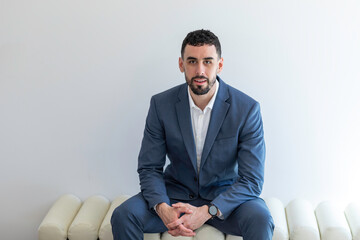 Handsome Bearded Groom Sitting on Bench w/ Blue Suit and Hands Clasped