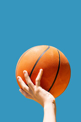 Hands Reaching for a Basketball Under a Blue Sky