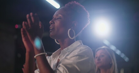 Woman clapping hands in worship, emotional expression of faith, spiritual celebration, Christian...