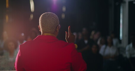 Fototapeta premium African descent woman preaching passionately during evangelical church service, raising hand while addressing congregation, spiritual leadership, guiding worshippers with faith and devotion
